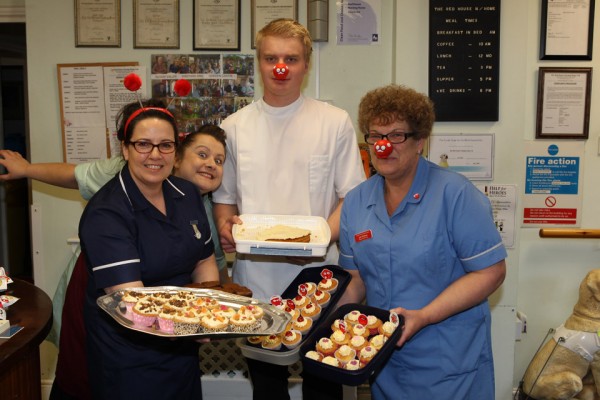 Tracey our cook photo bombs the picture as Angie, Harry and Julie show off the cakes they made to raise money.